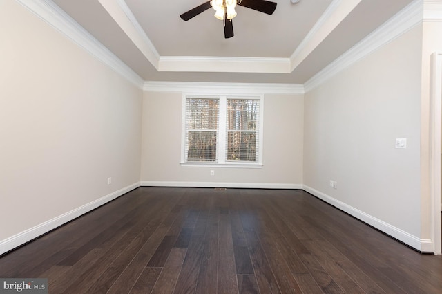 empty room featuring dark hardwood / wood-style flooring, a raised ceiling, ceiling fan, and ornamental molding