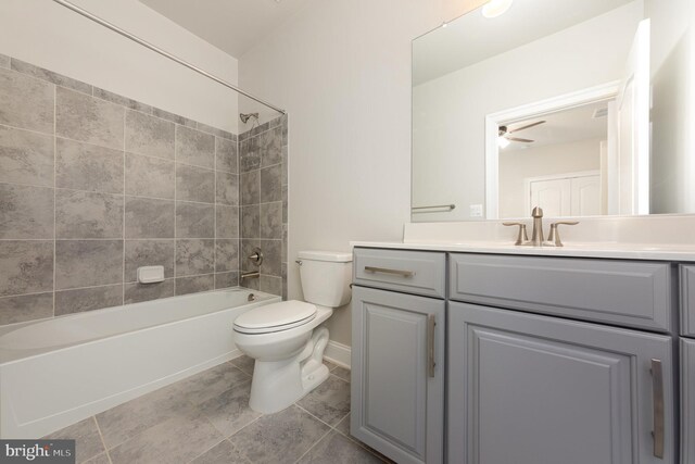 full bathroom with vanity, tile patterned floors, tiled shower / bath combo, ceiling fan, and toilet