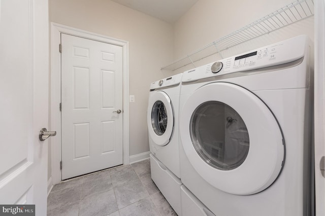 clothes washing area with light tile patterned floors and washing machine and clothes dryer