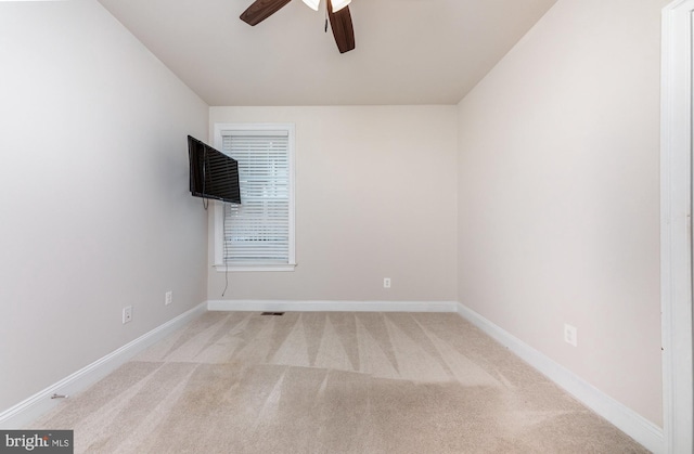 unfurnished room with light colored carpet and ceiling fan