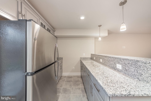 kitchen with kitchen peninsula, stainless steel fridge, light stone counters, decorative light fixtures, and gray cabinets