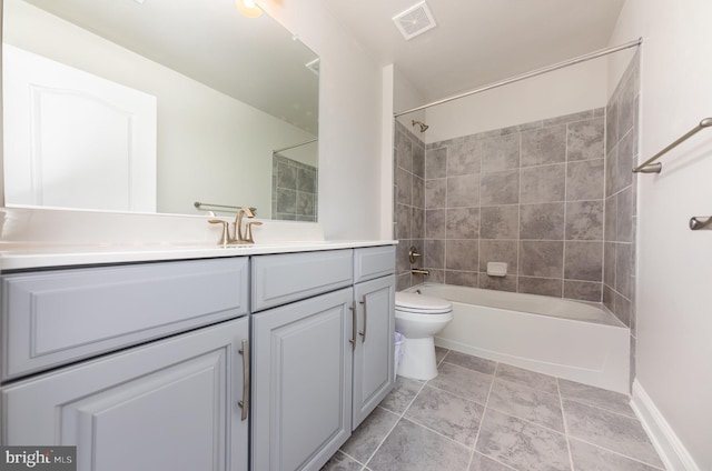 full bathroom with toilet, vanity, and tiled shower / bath