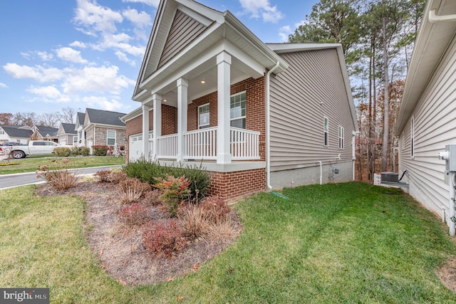 view of home's exterior with a lawn and a porch