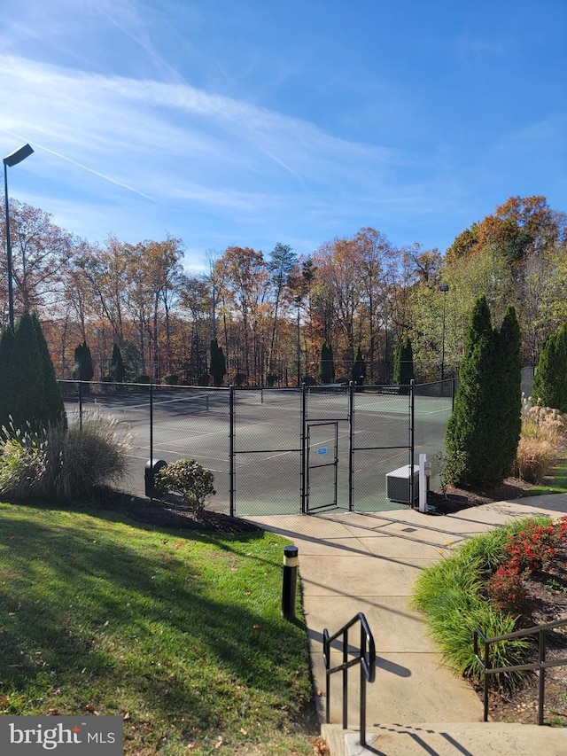 view of community with tennis court and a lawn