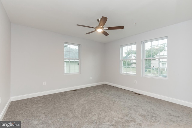 unfurnished room with carpet floors, plenty of natural light, and ceiling fan