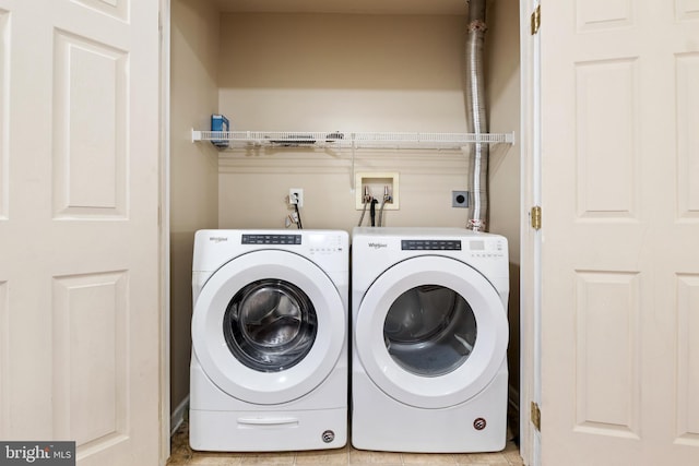 laundry area with washer and dryer and light tile patterned floors