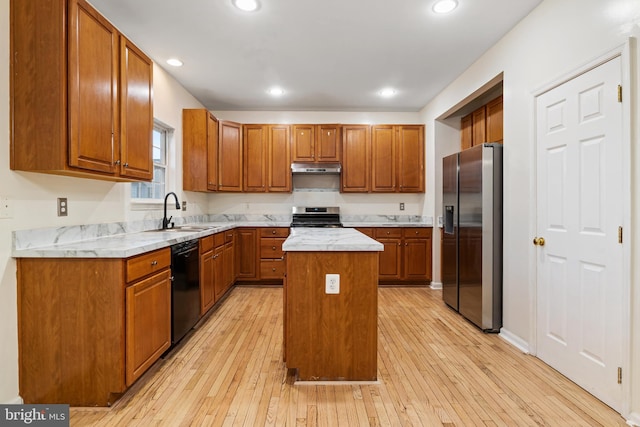 kitchen featuring light hardwood / wood-style flooring, a kitchen island, sink, and stainless steel appliances