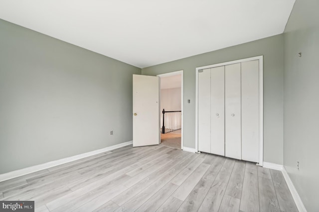 unfurnished bedroom featuring a closet and light hardwood / wood-style floors