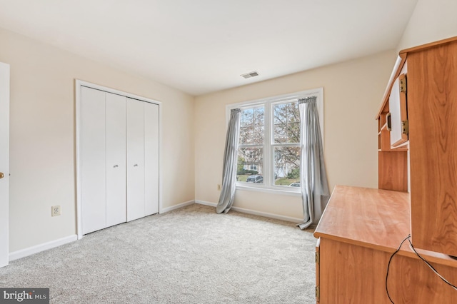 unfurnished bedroom featuring light colored carpet and a closet