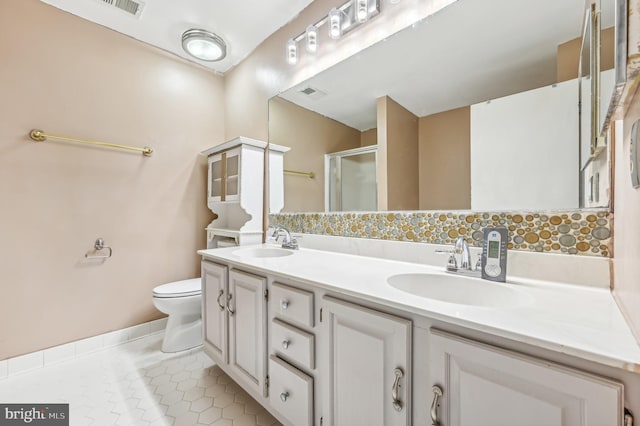 bathroom with toilet, vanity, tile patterned floors, and a shower with shower door