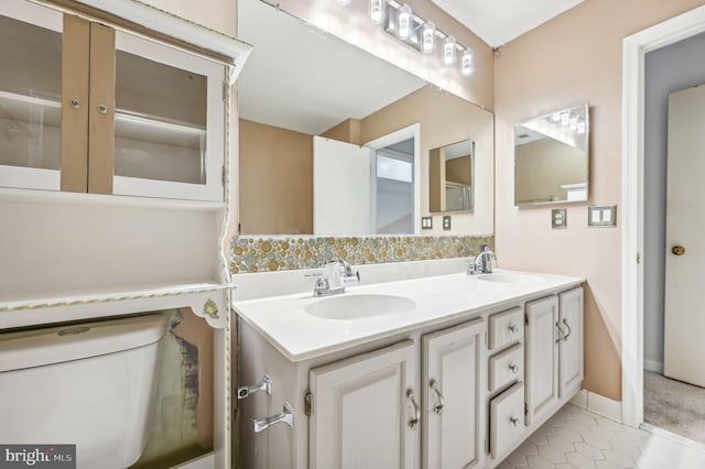 bathroom featuring tile patterned flooring, vanity, and toilet