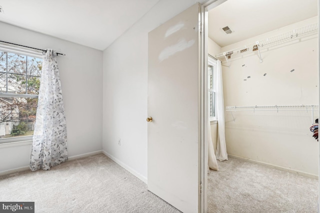 interior space with light carpet and a closet