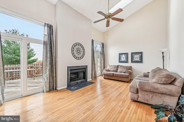 living room featuring ceiling fan, a wealth of natural light, light hardwood / wood-style floors, and high vaulted ceiling