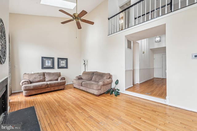 living room with high vaulted ceiling and light hardwood / wood-style floors