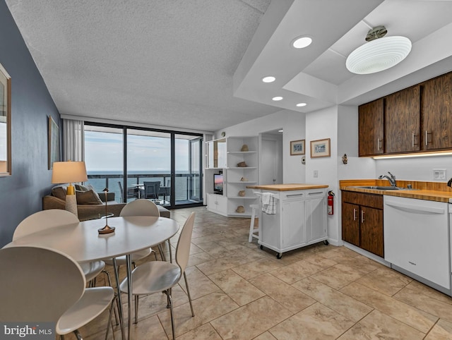 10900 Coastal Hwy Unit 915, Ocean City, MD 21842 - kitchen with dishwasher, butcher block countertops, a wall of windows, dark brown cabinets, and a textured ceiling