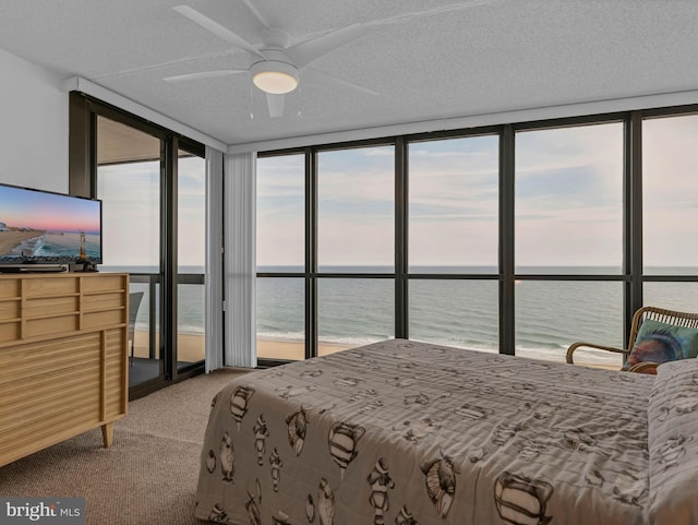10900 Coastal Hwy Unit 915, Ocean City, MD 21842 - bedroom featuring a water view, floor to ceiling windows, light colored carpet, and a textured ceiling