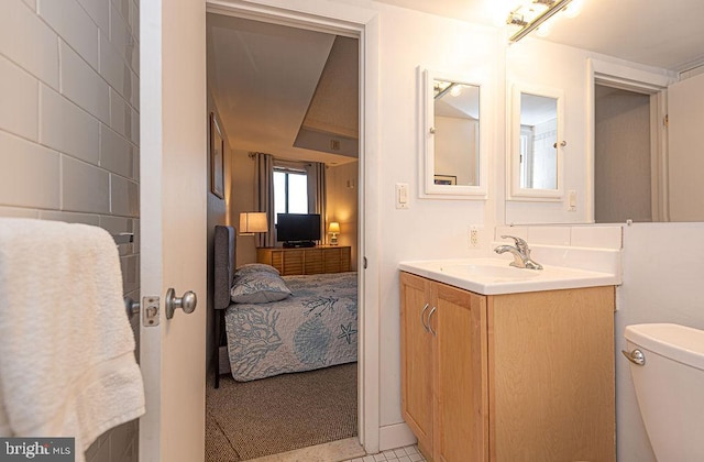 bathroom with tile patterned flooring, vanity, and toilet