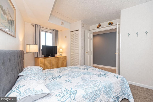 carpeted bedroom featuring a textured ceiling and a closet