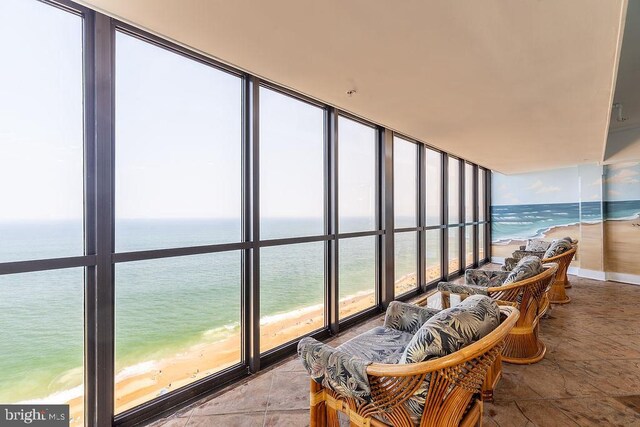 sunroom with a beach view and a water view