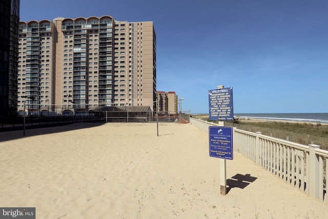 view of property's community featuring a beach view, volleyball court, and a water view