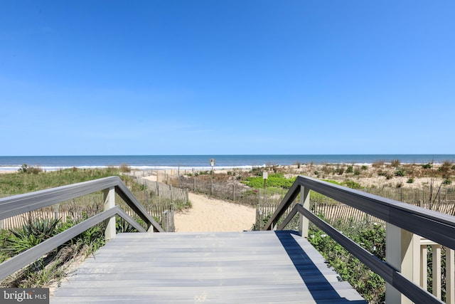 wooden deck with a beach view and a water view