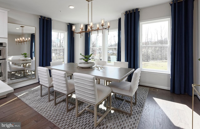 dining space with plenty of natural light, dark hardwood / wood-style flooring, and a notable chandelier