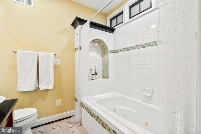 full bathroom featuring toilet, vanity, tile patterned floors, and shower / bath combo with shower curtain