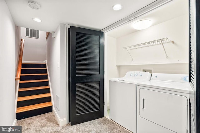 laundry area with washing machine and clothes dryer and light colored carpet