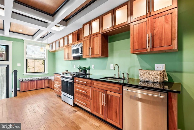 kitchen featuring coffered ceiling, hanging light fixtures, sink, appliances with stainless steel finishes, and beamed ceiling