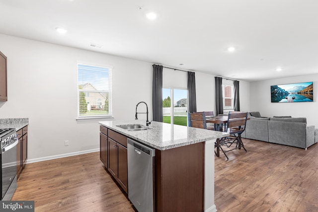 kitchen with sink, dark hardwood / wood-style flooring, a kitchen island with sink, and appliances with stainless steel finishes