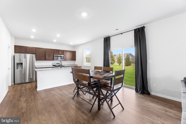 dining space featuring sink and dark wood-type flooring