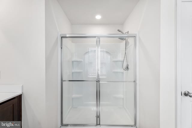 bathroom featuring vanity and an enclosed shower