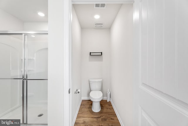 bathroom with walk in shower, wood-type flooring, and toilet