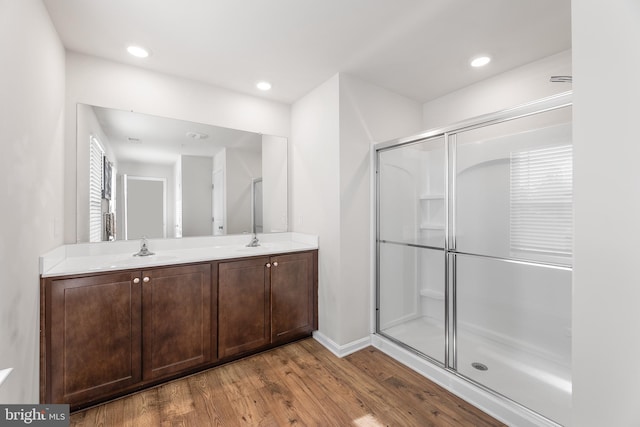 bathroom with vanity, an enclosed shower, and hardwood / wood-style flooring