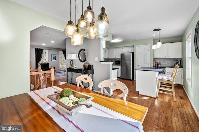 dining space with dark hardwood / wood-style flooring and an inviting chandelier