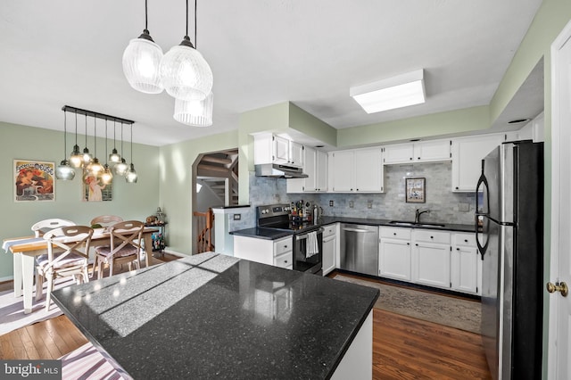 kitchen featuring white cabinets, dark wood-type flooring, stainless steel appliances, and pendant lighting