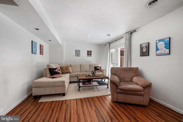 living room with a textured ceiling and dark wood-type flooring