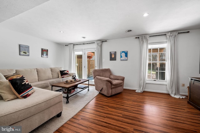 living room with dark wood-type flooring and a textured ceiling