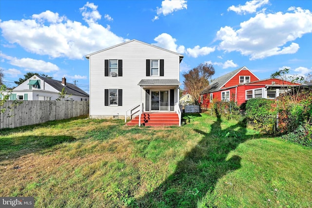 rear view of property featuring a yard