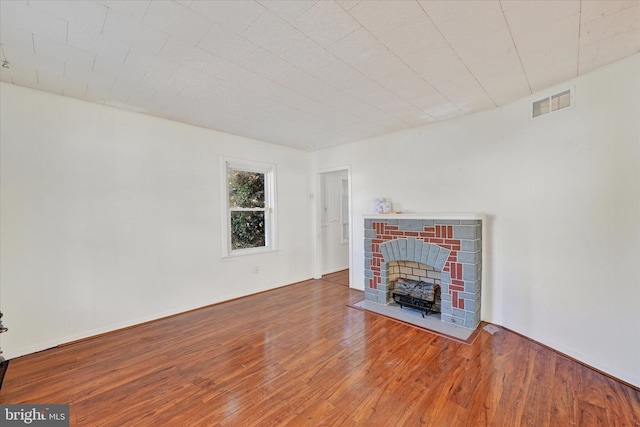 unfurnished living room with wood-type flooring and a fireplace