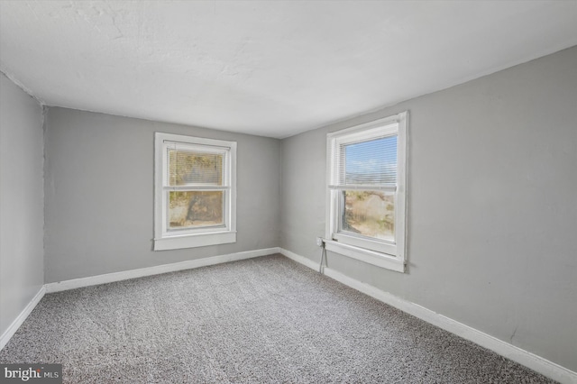 carpeted spare room featuring a healthy amount of sunlight