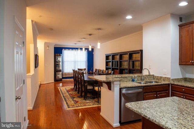 kitchen with a breakfast bar, crown molding, sink, stainless steel dishwasher, and dark hardwood / wood-style floors