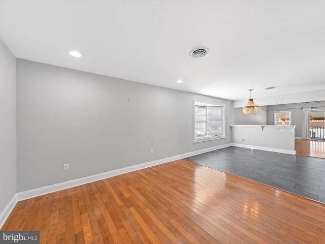 unfurnished living room featuring hardwood / wood-style floors and a notable chandelier