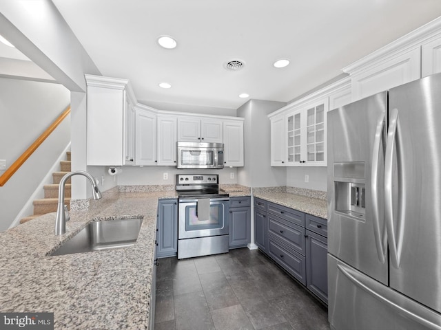 kitchen with white cabinetry, sink, stainless steel appliances, light stone counters, and gray cabinets