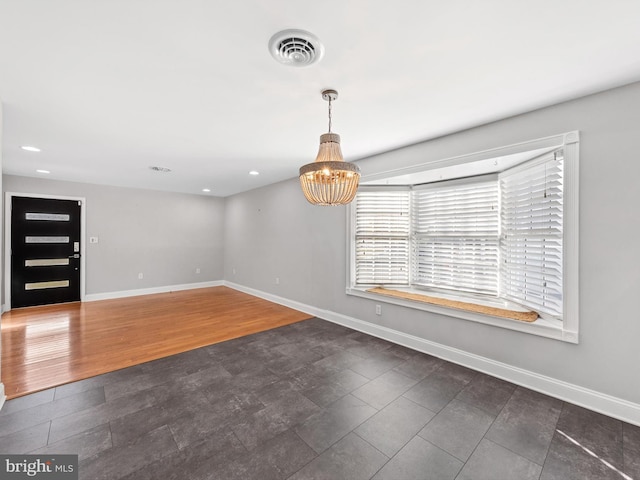 entryway with dark wood-type flooring and an inviting chandelier