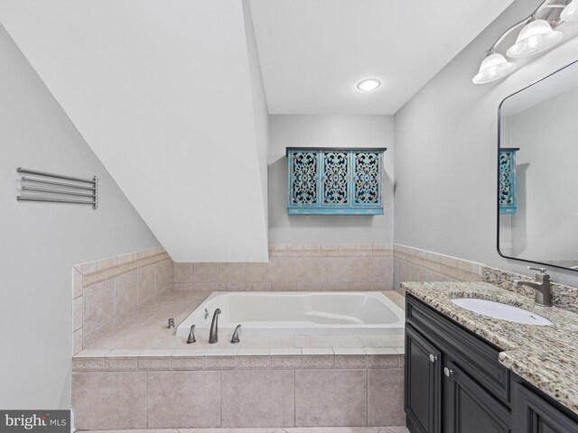 bathroom with tiled bath and vanity