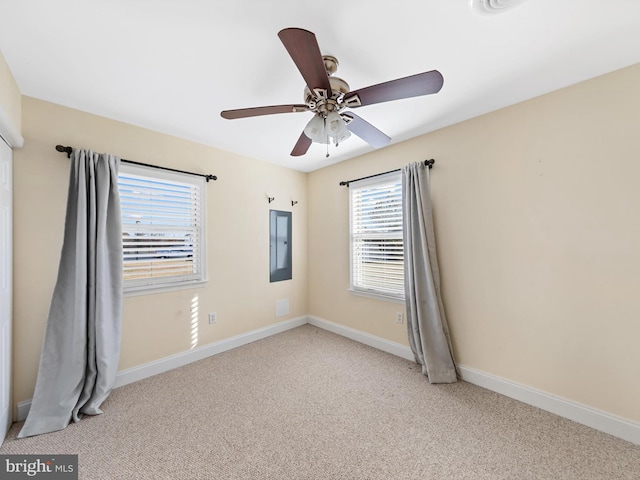 carpeted empty room featuring electric panel, a wealth of natural light, and ceiling fan