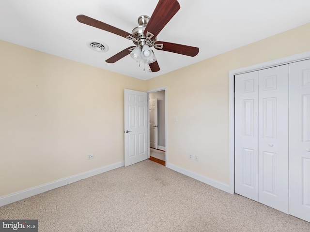 unfurnished bedroom with ceiling fan, a closet, and light colored carpet