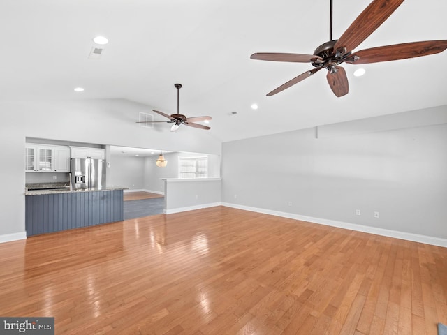 unfurnished living room with ceiling fan, light hardwood / wood-style floors, and lofted ceiling