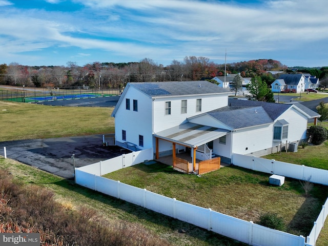 view of front of property with central AC, a deck, and a front lawn